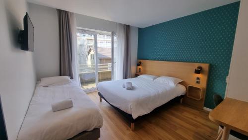 安纳马斯Oskar Hotel的配有两张床的客房,设有绿色的墙壁和窗户