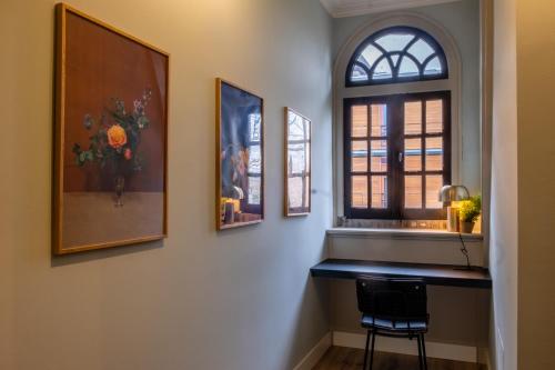 布雷达Hotel Botanique Breda的客房设有窗户、桌子和椅子。