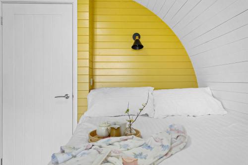 韦尔斯Honeycrisp, Apple Tree Glamping, Nr Wells的一间卧室配有一张黄色墙壁的床