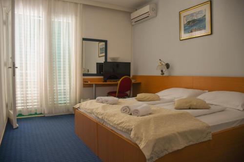 赫瓦尔Hotel Sirena Hvar的一间卧室配有两张床和一张带电脑的书桌