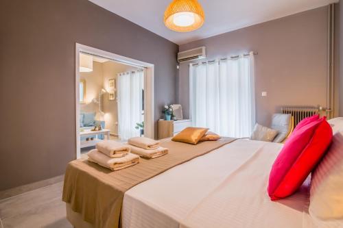 雅典Glyfada's Central Apartment的一间卧室配有一张大床和红色枕头