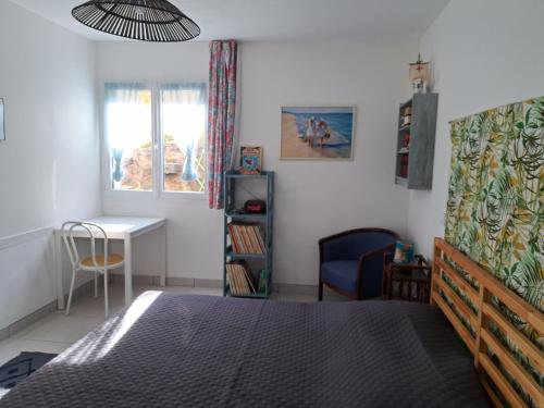 滨海巴纽尔斯la belle bleue的一间卧室配有一张床、一张桌子和一把椅子