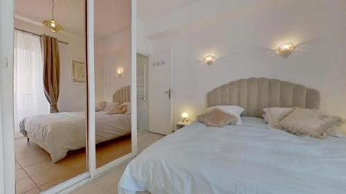 马赛马赛乐皮西亚斯港口公寓的一间卧室配有两张床和镜子