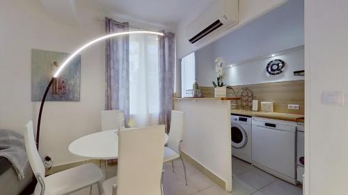 马赛马赛乐皮西亚斯港口公寓的厨房配有桌子和白色的桌椅