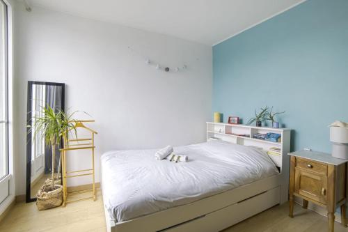 巴黎Charming flat nearby the Ourcq Canal - Paris - Welkeys的一间卧室配有一张蓝色墙壁的床
