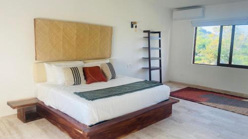锡瓦塔塔内霍Luana suites- Suite Koya的卧室配有带枕头的床铺和窗户。