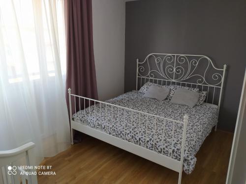 VoždivacApartman 9的一间带白色床和金属床头的卧室