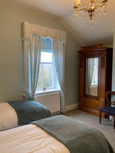 林肯The Old Lodge Guest House的一间卧室设有两张床和窗户。