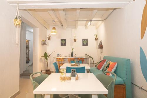 卡塔赫纳El Barrio Hostal的一间配备有白色桌子和蓝色椅子的用餐室