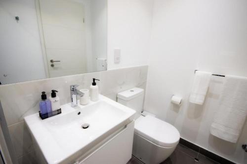 阿克拉Splendid Apartments @ The Lennox的白色的浴室设有水槽和卫生间。