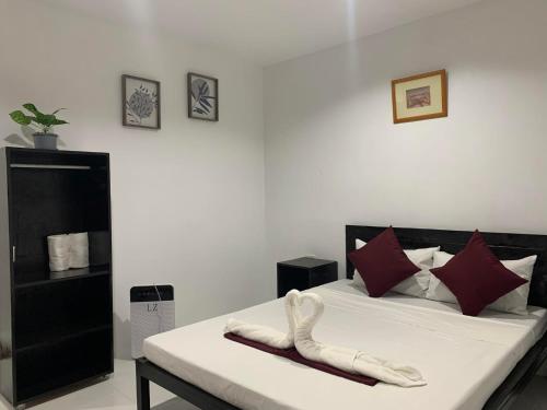 莫阿尔博阿Fil's Resort的一间卧室配有带白色床单和红色枕头的床。