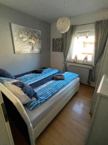 纽伦堡Wie Daheim的一间卧室配有一张带蓝色床单的床和一扇窗户。