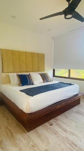 锡瓦塔塔内霍Luana suites- Suite Nikté的一间卧室设有一张大床和大窗户