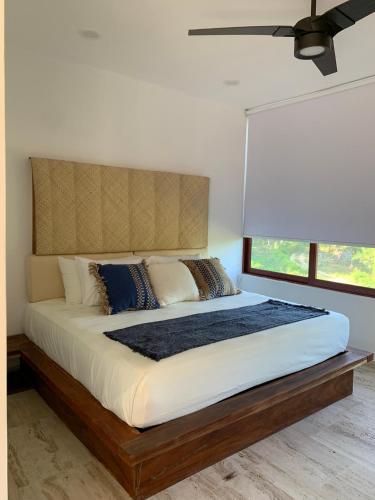 锡瓦塔塔内霍Luana suites- Suite Nikté的一间卧室设有一张大床和大窗户