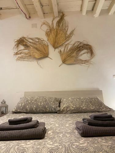 巴列塔B&B Le Statuine的卧室配有一张挂着一些植物的床。