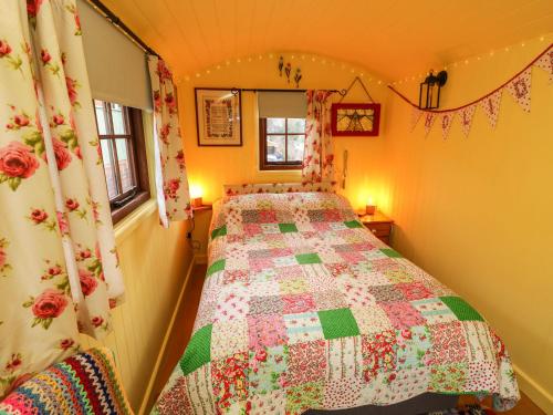 文特诺Little Worsley and The Shepherds Hut的一间卧室配有床,床上装有被子