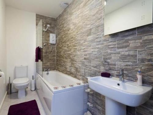 StanningleyNazarene apartments in Leeds的一间带水槽、浴缸和卫生间的浴室