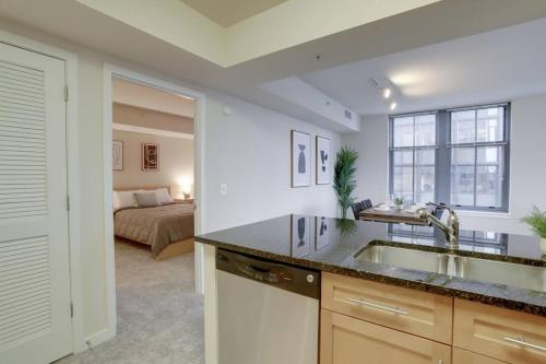 阿林顿Wonderful 2 BR Condo At Pentagon City with Gym的一个带水槽的厨房和一张位于客房内的床