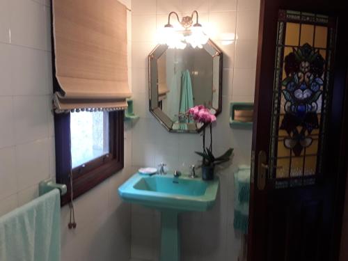 AmésCasa Pontevella的浴室设有蓝色水槽和镜子