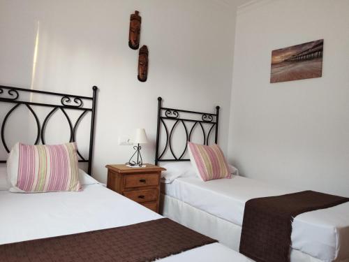 奇克拉纳－德拉弗龙特拉Casa Rural Asgard的一间卧室配有两张床和一个带灯的床头柜。