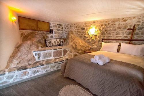 伊兹拉Braxos A beautiful rocky place的酒店客房设有两张床和石墙。