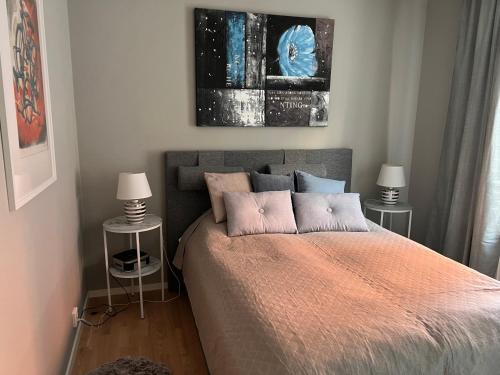 斯德哥尔摩Haga 1 bedroom Apartment的一间卧室配有一张带两张桌子和两盏灯的床。