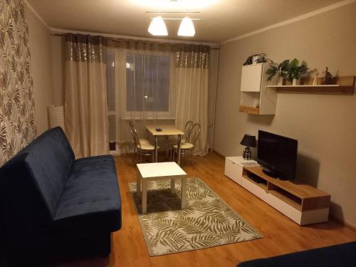 琴斯托霍瓦Apartament M-3的客厅配有蓝色的沙发和桌子