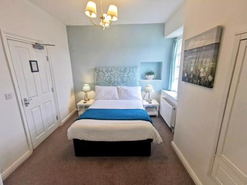 温德米尔The Elleray的一间卧室配有一张带蓝色和白色床单的床。