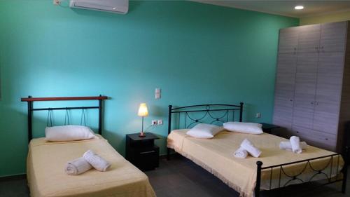 阿利卡纳斯Agia Kiriaki Bungalows的蓝色墙壁客房的两张床