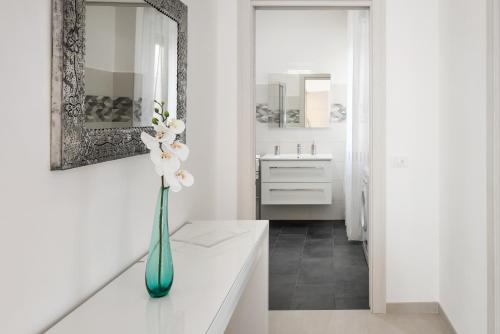 维罗纳Civico40 Luminoso appartamento con balconi e garage privato的白色的浴室,在柜台上放花瓶