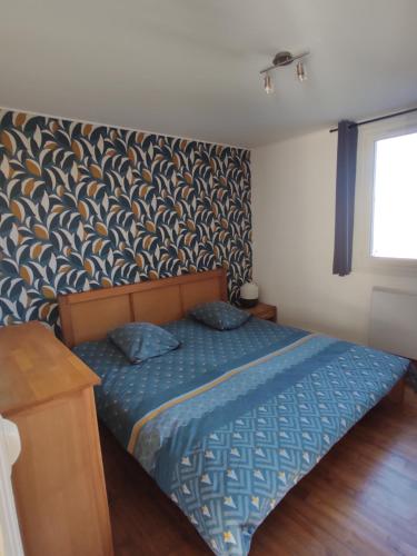 勒克罗图瓦Le Crotoy plage Baie de somme appartement l'Avocette的一间卧室配有一张带蓝色棉被的床