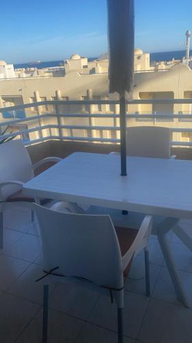 加鲁查Apartamento Andalucía - vistas al mar, playa, puerto deportivo, garaje的阳台上配有白色的桌椅
