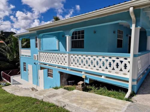 卡斯特里My Gem in the Caribbean的蓝色房屋 - 带白色阳台
