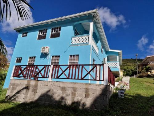 卡斯特里My Gem in the Caribbean的蓝色房子的顶部设有阳台