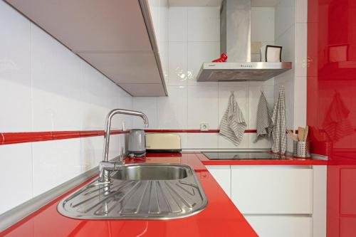 马德里Bonito, Práctico y muy bien comunicado的红色和白色的厨房设有水槽