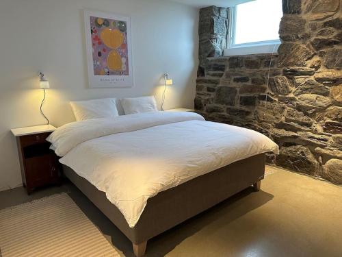 KarvågStorlauvøya The Atlantic Ocean Road的一间卧室设有一张带石墙的大床