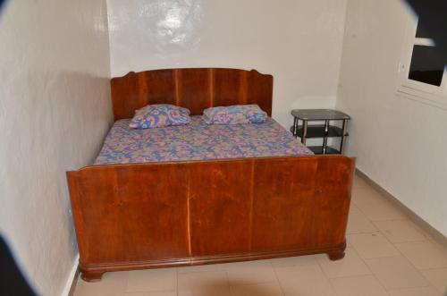 达喀尔Villa Luxueuse à Ouakam的卧室内的一张带两个枕头的木床