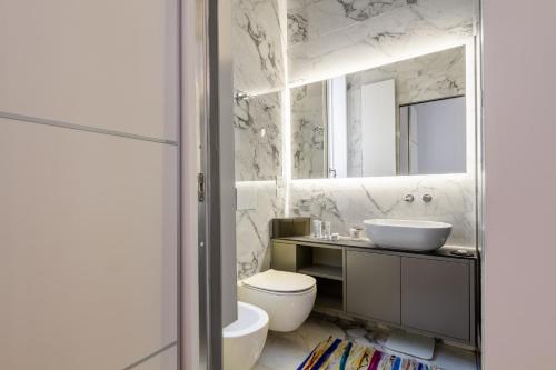 米兰B&B Liberty Suite Milan的一间带水槽、卫生间和镜子的浴室