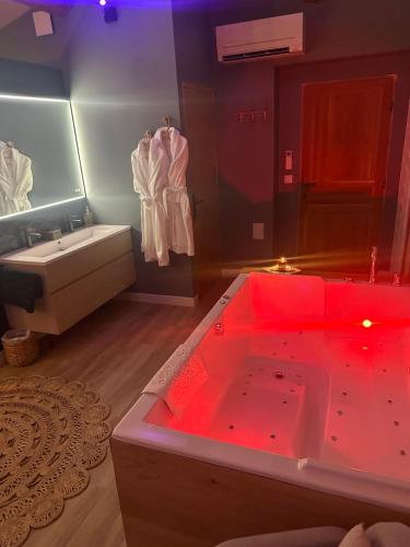 蒙彼利埃Mas Hinaiti - Suite romantique avec Spa et écran géant de cinéma的一间带红色照明的大浴缸的浴室