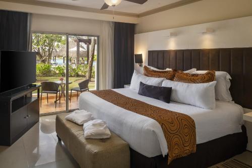 蓬塔卡纳Jewel Palm Beach的酒店客房设有一张大床和一台电视。