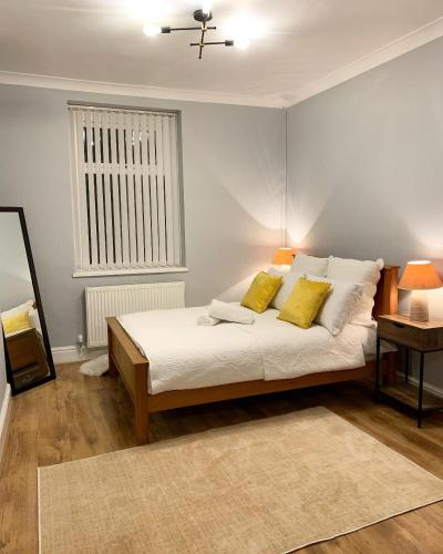 卡迪夫Cardiff Home的一间卧室配有一张带两个黄色枕头的床