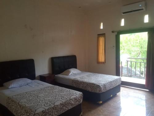 乌鲁瓦图毕龙博特家庭旅馆的两张床位于带窗户的房间内