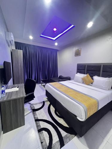 拉各斯De Rigg Place Embassy的酒店客房设有一张大床和一台电视机。