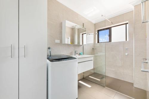 纳鲁马Apollo Unit 21 1st Floor的白色的浴室设有水槽和淋浴。