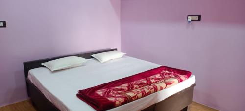 JagdalpurGovind Niwas Homestay的一张白色的床,上面有红毯
