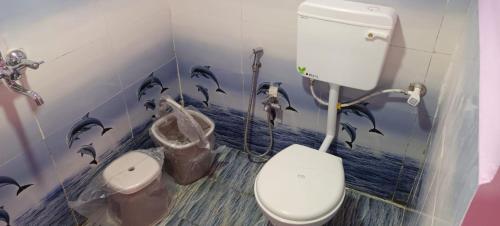JagdalpurGovind Niwas Homestay的浴室设有卫生间,墙上涂有海豚
