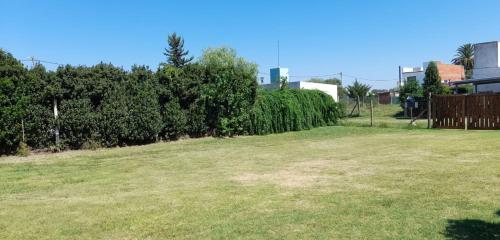 胡宁Hermosa Casa Quinta en Junin的草场,有栅栏和灌木