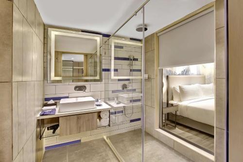 苏拉特Park Inn by Radisson Surat的浴室设有床、水槽和镜子