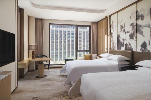 云浮云浮新兴筠城喜来登酒店的酒店客房设有两张床和大窗户。