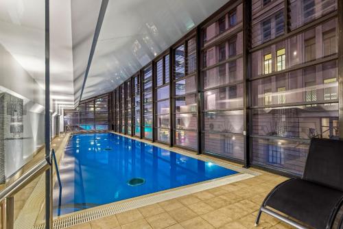 阿德莱德培泊维莫斯酒店的一座大型游泳池,位于一座带窗户的建筑内
